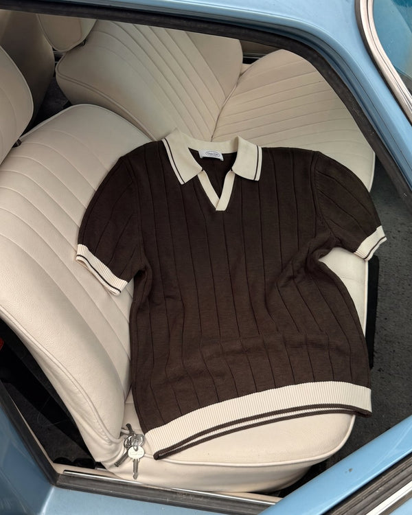A knit polo laid across a vintage car's back seat